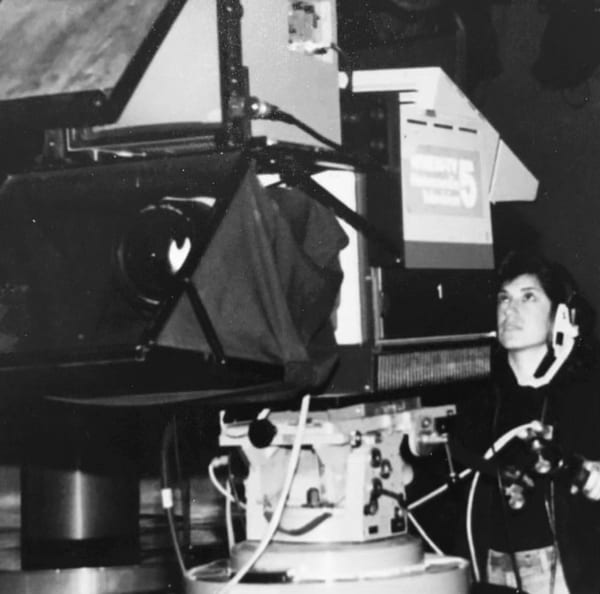 Karen Vitale beside a television studio camera during her earlier career as a producer